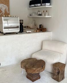 a white room with two stools and a coffee maker