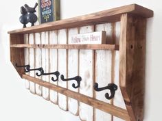 a wooden shelf with metal hooks on it