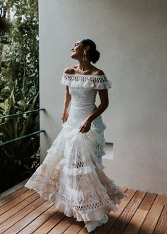 a woman in a white dress is standing on a wooden floor and looking up at the sky