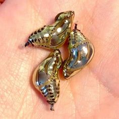 three small silver birds sitting on top of a persons hand in front of the camera