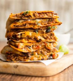 a stack of quesadillas stacked on top of each other with toppings