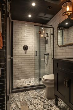 a bathroom with black and white tile flooring and walls, along with a walk in shower