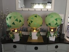 three green lanterns sitting on top of a dresser