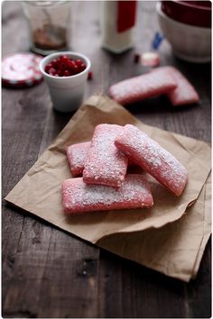 some powdered sugar cookies are on a brown paper bag