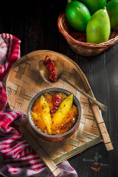 a bowl filled with fruit on top of a wooden tray