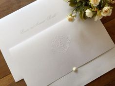 a bouquet of flowers sits on top of an envelope with the word love written in cursive writing