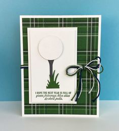 a handmade card with a golf ball and tee on the green tartan background