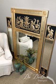 a mirror sitting on top of a floor next to a white chair and vases