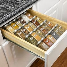 an open drawer in a kitchen filled with spices