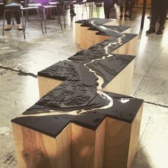 three wooden benches sitting on top of a floor next to each other in a room