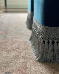 a close up view of a blue ottoman with tassels