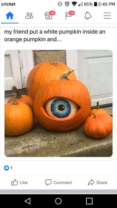 two pumpkins with an eye on them and three smaller pumpkins sitting next to each other