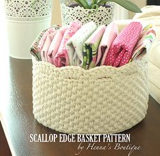 a basket filled with clothes sitting on top of a table next to a potted plant