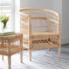 a wicker chair and foot stool in front of a window