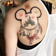 a woman with a mickey mouse tattoo on her back