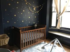 a baby's room with stars painted on the wall, and a crib