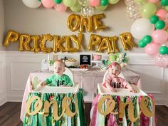 two babies are sitting in their cribs at a one - year birthday party