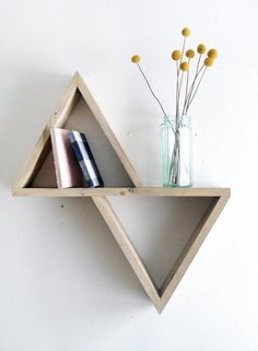 two wooden shelves with vases and flowers on each shelf in front of a white wall