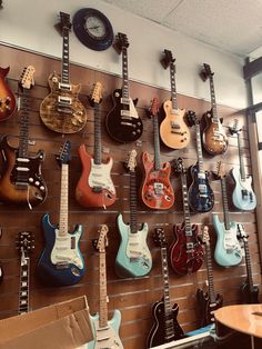 many guitars are hanging on the wall