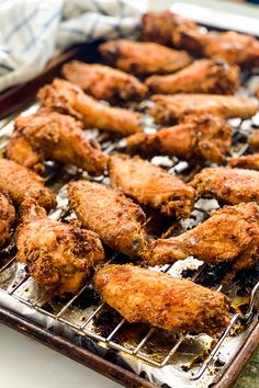 chicken wings are cooking on a grill in the kitchen