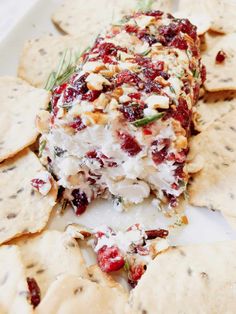 a white plate topped with crackers covered in cheese and cranberry toppings