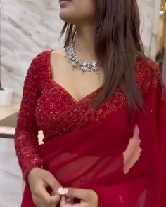 a woman wearing a red sari and jewelry