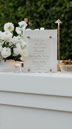 a table topped with white flowers next to a sign