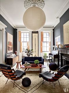 a living room filled with lots of furniture and a chandelier hanging from the ceiling