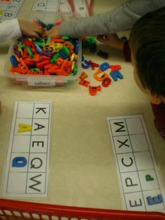 two children playing with letters and numbers on a table