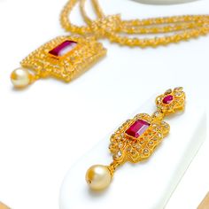 Crafted with exquisite attention to detail, this 22k yellow gold set weighs 54.8 grams and features a royal vintage design. It is adorned with uncut diamonds (Polki), totaling 11.18 carats, and further embellished with rubies and pearls, collectively weighing 34.2 carats. The set has a length of 16 inches, with an impressive drop length of 2.2 inches, and is secured with a hook lock and adjustable links for tailored comfort. The matching earrings, at a length of 2.1 inches, complete the set, eac Polki Necklace Set, Bridal Jewelry Necklace, Diamond Pendant Sets, Polki Necklace, Modern Bracelets, Fancy Necklace, Fancy Rings, Mens Gold Rings, Diamond Necklace Set