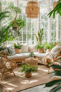 a living room with lots of plants and wicker furniture in front of large windows