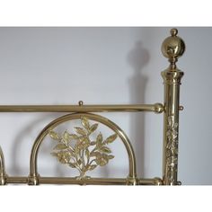 a gold metal bed frame with flowers on it