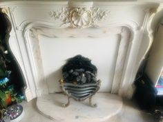 a white fireplace with a bunch of rocks on it's mantle and decorations around it