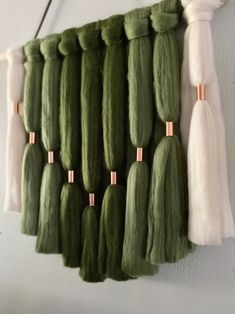 several green and white tassels hanging on a wall