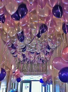 a room filled with balloons and streamers hanging from the ceiling