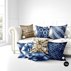 a white couch with blue and brown pillows sitting on it's side, next to a window