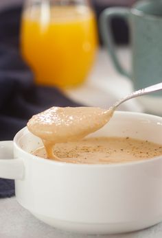 there is a spoon full of soup in a bowl with the words plantain porridge on it