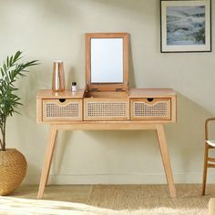 a wooden table with two drawers and a mirror on it in front of a potted plant