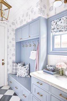 a bathroom with blue cabinets and white counter tops in front of a checkered floor