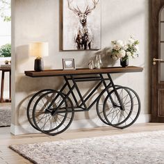 a bicycle is sitting on a table in front of a wall with pictures and flowers