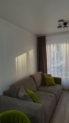 a living room filled with furniture next to a window covered in sheer curtained drapes