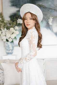 a woman in a white dress and hat posing for the camera with her hands on her hips