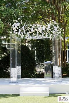 an outdoor ceremony setup with white flowers and greenery