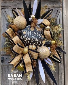 a wreath that has been decorated with gold, black and white decorations on top of it