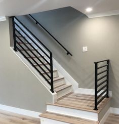 an empty room with stairs and hard wood flooring