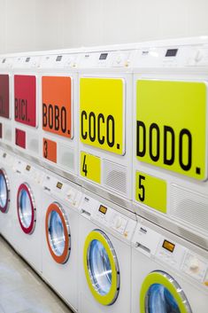 several washers and dryers are lined up in a row with signs on them