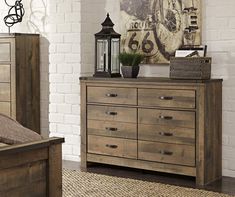 a bedroom scene with focus on the dresser and bed sideboard, which has a large clock above it