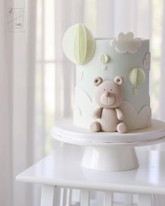 a white cake with a teddy bear on top