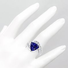 a hand with a ring on it that has a blue heart shaped diamond in the middle