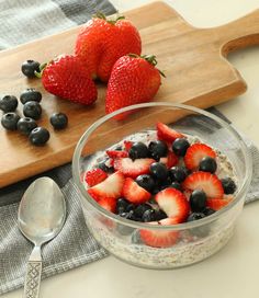 overnight oats with yogurt and berries in a glass bowl on a cutting board